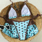 Bikini set flat lay turned over, white lining inside the triangle cups and the brown hip ties untied