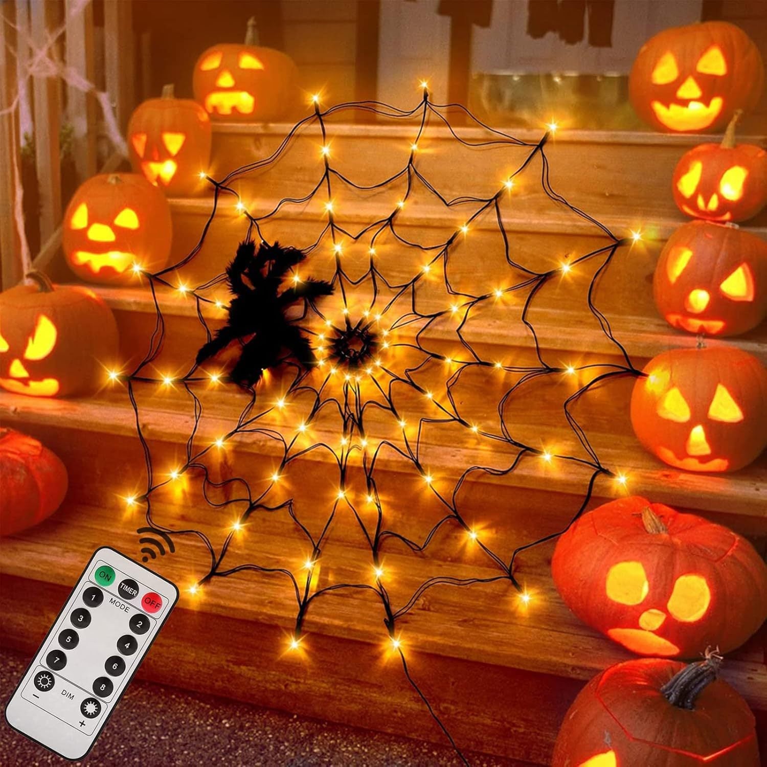 Orange lit spider web net light with a black spider on steps with pumpkins and a remote