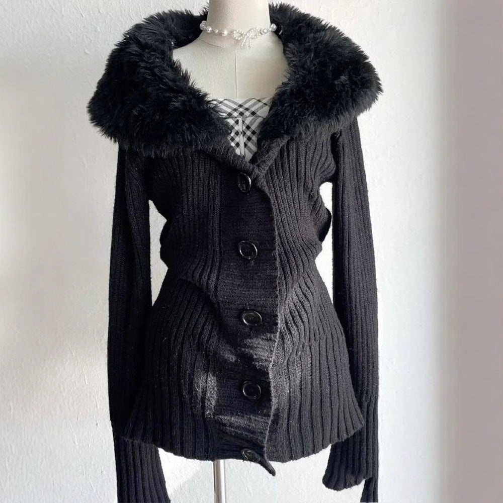 Black cardigan with plush collar and ribbed body on a mannequin, pearl necklace and plaid top for styling