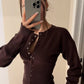 Buttoned front detail of the fine rib knit cardigan with a collarless round neck