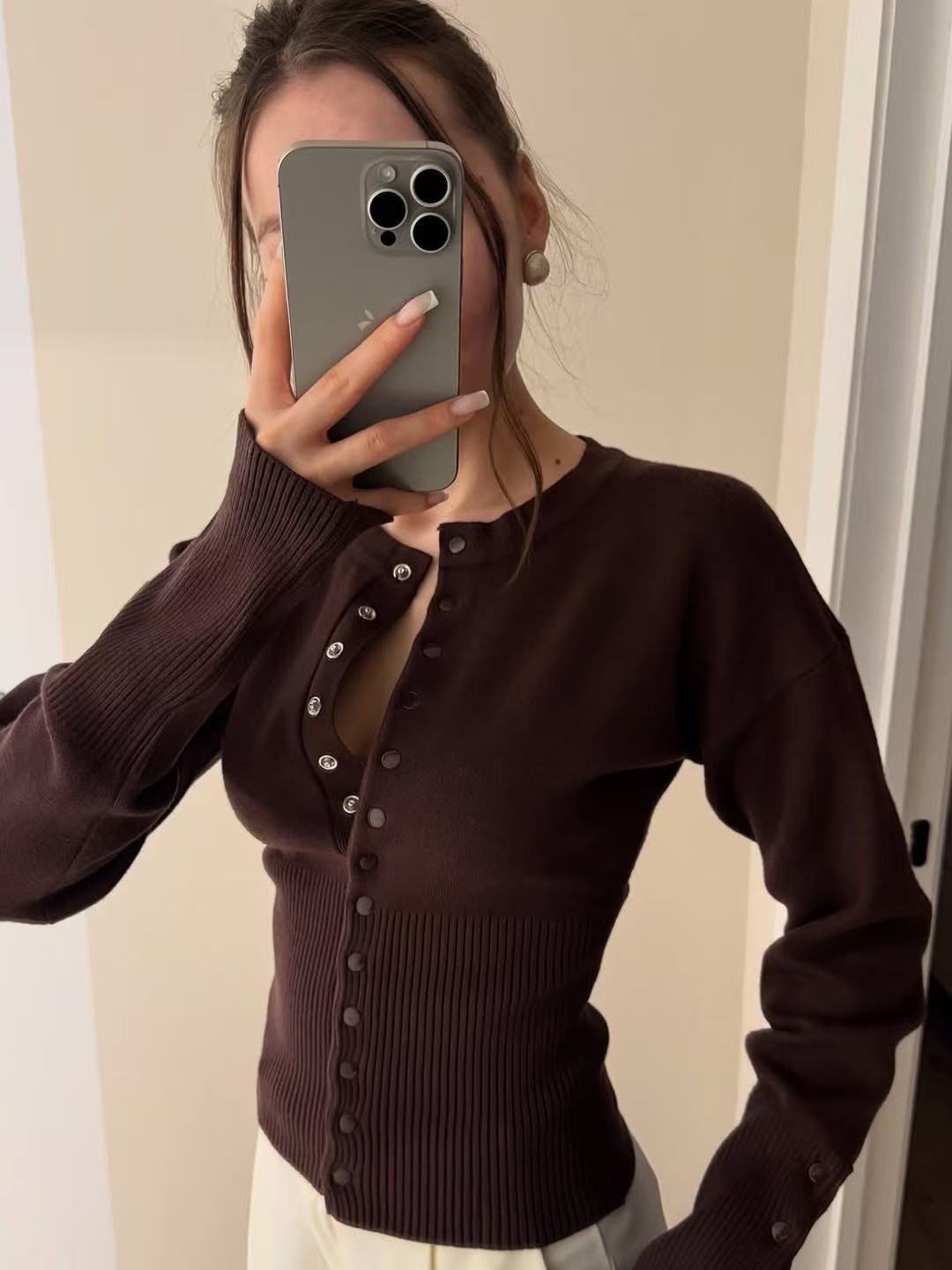 Buttoned front detail of the fine rib knit cardigan with a collarless round neck