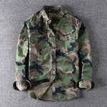 Men's washed camouflage long sleeve button shirt with two flap chest pockets laid flat with the sleeves rolled