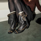Coffee brown vintage boots on a low curved heel with a wrap strap and tassel at the ankle