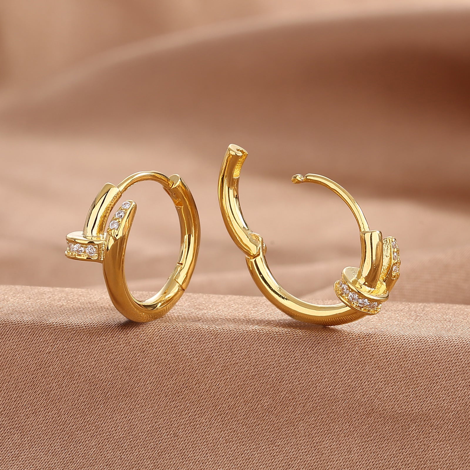 Gold nail stud earring shown from the side with its straight post and back