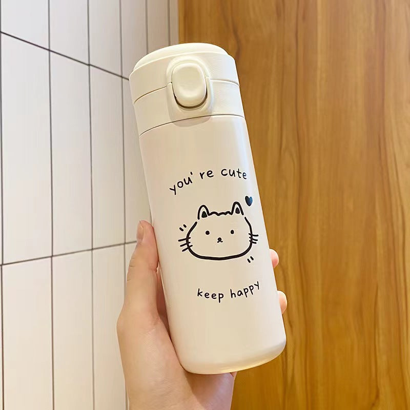 Cream insulated bottle held in one hand, black line drawn cat face and the words you are cute