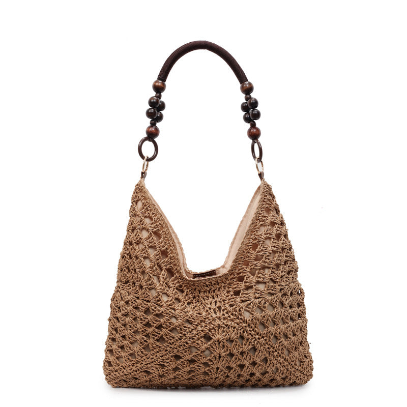 Blue and white open-weave hobo bag with a light beaded handle shown front on a white studio background