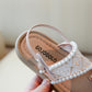 Close up of the pearl-trimmed front strap on the girls' summer sandals