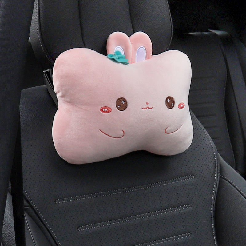 Pink rabbit headrest pillow with a teal bow shown alone on a black car seat