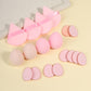 Row of foam makeup sponges and velvet powder puffs laid out by color