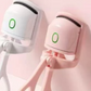 Close view of the green ring indicator lit on the white and pink eyelash curler heads