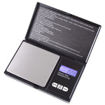 Open black pocket digital scale with a stainless steel platform and a blue backlit display reading 0.00, 500 g capacity