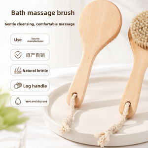 Two natural wood bath brushes with round boar bristle heads and cotton hanging loops on a round tray