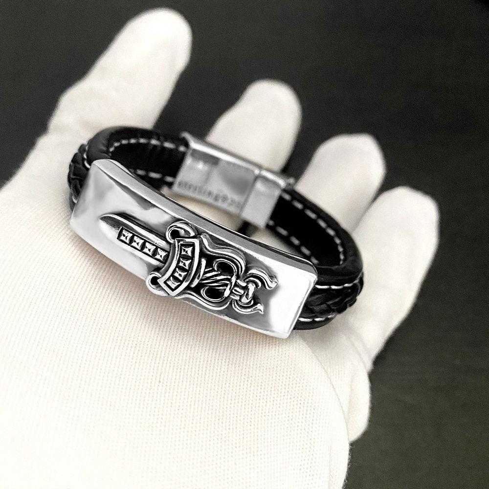 Side profile detail of the black leather cuff and its riveted silver concho