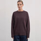 Side angle of the relaxed-fit knit pullover sweater showing sleeve drape