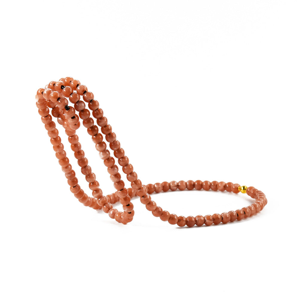 Rose pink beaded wine bottle holder with dark specks on a white background, Rose Pink option