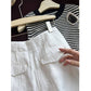 Close view of white linen shorts back flap welt pocket detail