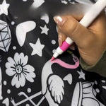 Hand coloring a flamingo shape pink on the black and white outline coloring blanket