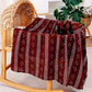 Large cotton muslin gauze baby blanket laid out, showing the loose breathable weave and print
