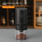 Black electric coffee grinder with a power button and ground coffee in a clear cup, ceramic grinding core text overlay