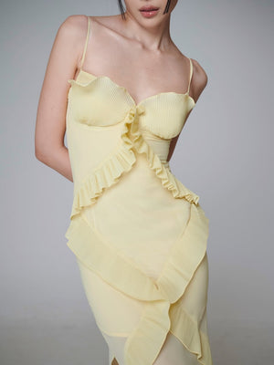 Close view of the yellow dress bodice, knife pleated cups and a small self tie bow above the crossing ruffle bands