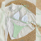 Close up of mint green ribbed bikini fabric and tie detail on a white cloth
