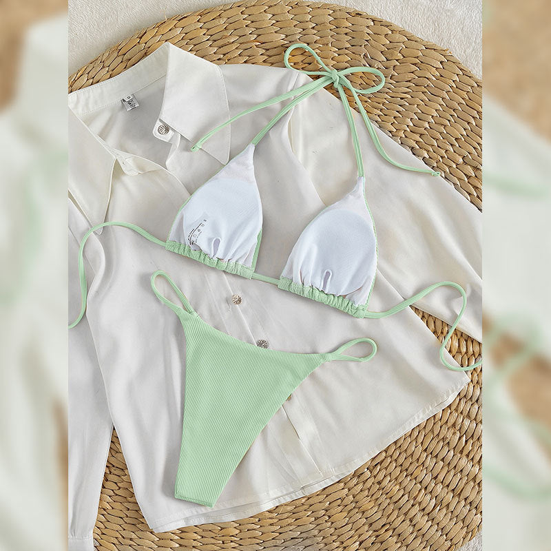 Close up of mint green ribbed bikini fabric and tie detail on a white cloth