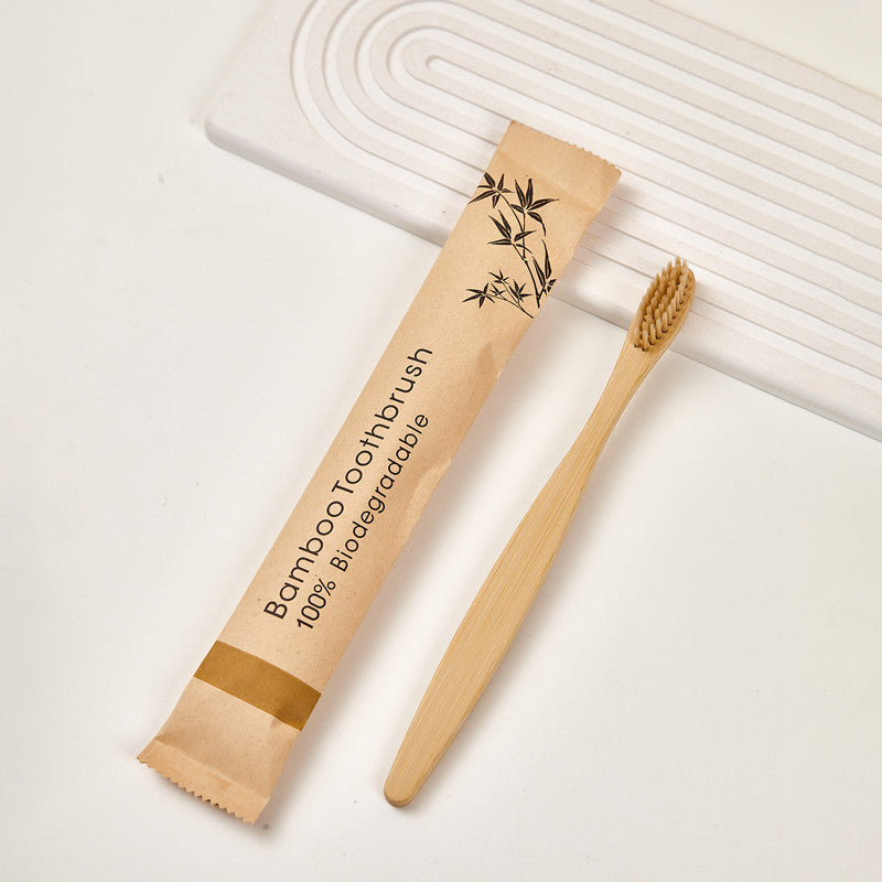 Bamboo toothbrush in a kraft paper sleeve printed with a bamboo leaf motif
