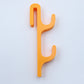 Orange resin single sided double hook with two arms stacked, seen from the front on a light background