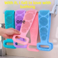 Silicone shower back scrubber straps in four colors hanging by their handle loops