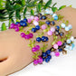 Close view of glossy round beads bunched like berries with matte green enamel leaves