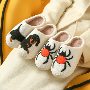 Cream plush slippers with tufted black dachshund and black spider designs on a cream coat