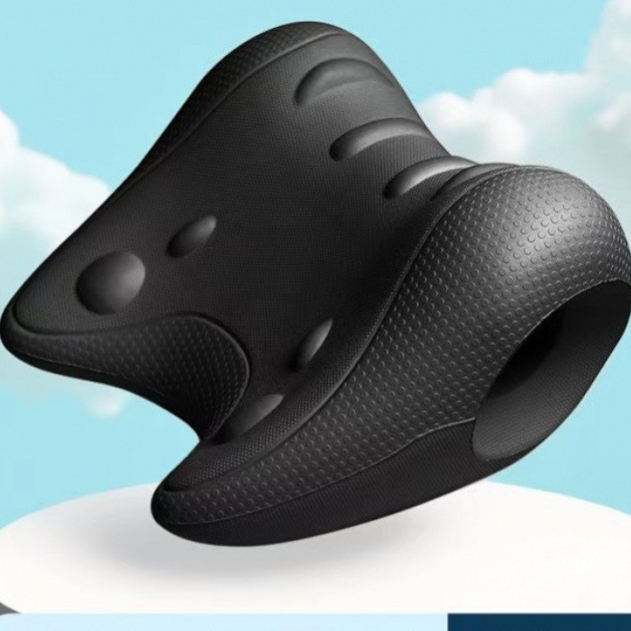Black contoured foam neck pillow with textured surface, raised nodes and round opening against a sky