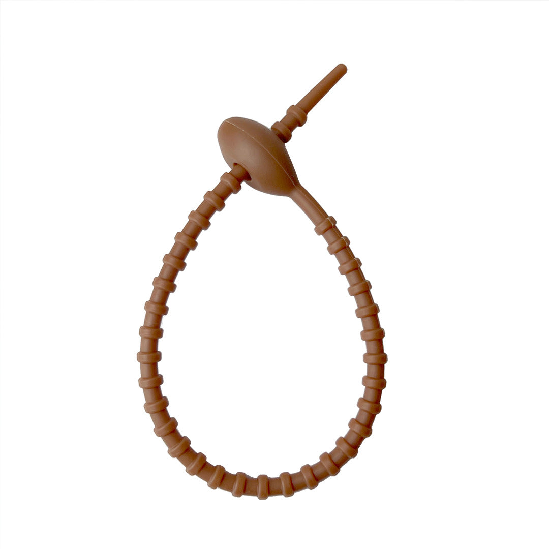 Tadpole silicone tie looped around a wrist to show how flexible the strap is