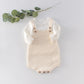 Knitted infant romper laid flat to show the one-piece shape