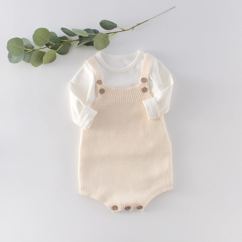 Knitted infant romper laid flat to show the one-piece shape