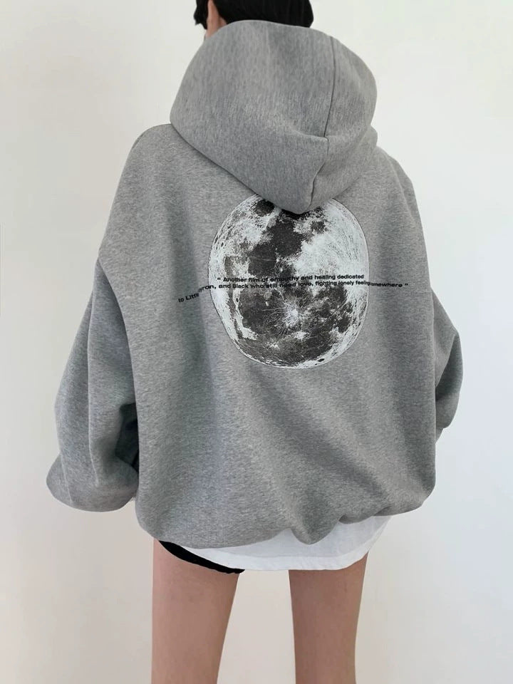 Light gray oversized hooded sweatshirt seen from behind with a large grayscale moon print across the back
