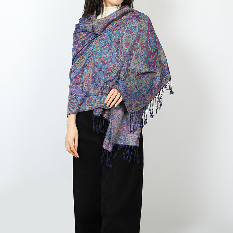 Woman wearing a blue and purple paisley shawl over her shoulders with navy tassels at the front