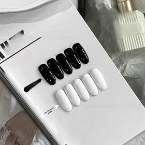 Glossy pure black and pure white press on nail swatches on a white tray