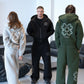 Gray hoodie back with clover motif, black zip hoodie front and green hoodie back in a lounge setting
