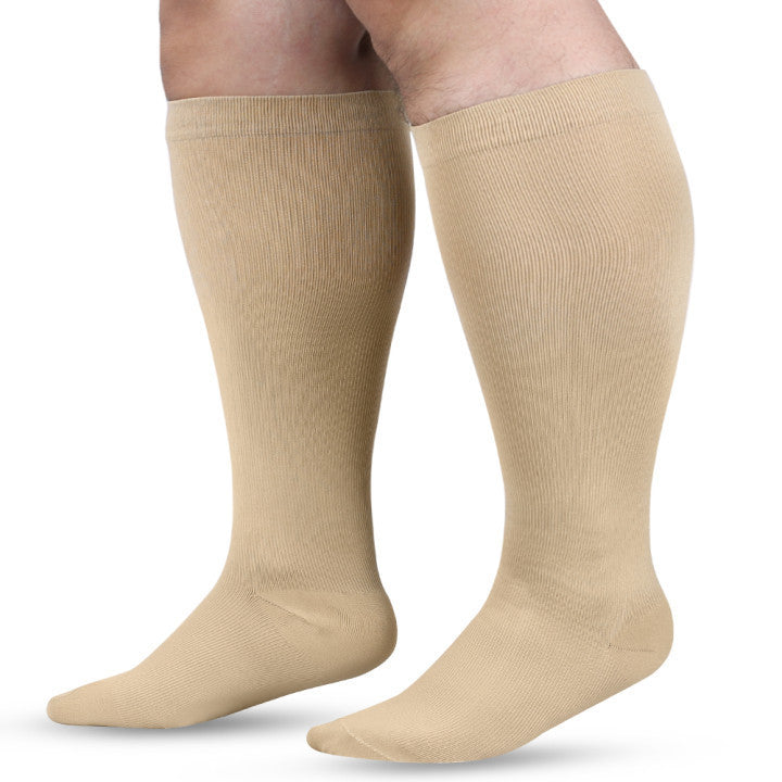 Plus size compression sock in a solid colour shown against a plain pale backdrop