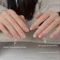 Two hands comparing nails with and without the applied crystal coating nail powder