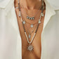 Silver layered bohemian necklace with a spiral sun pendant and hamsa charm