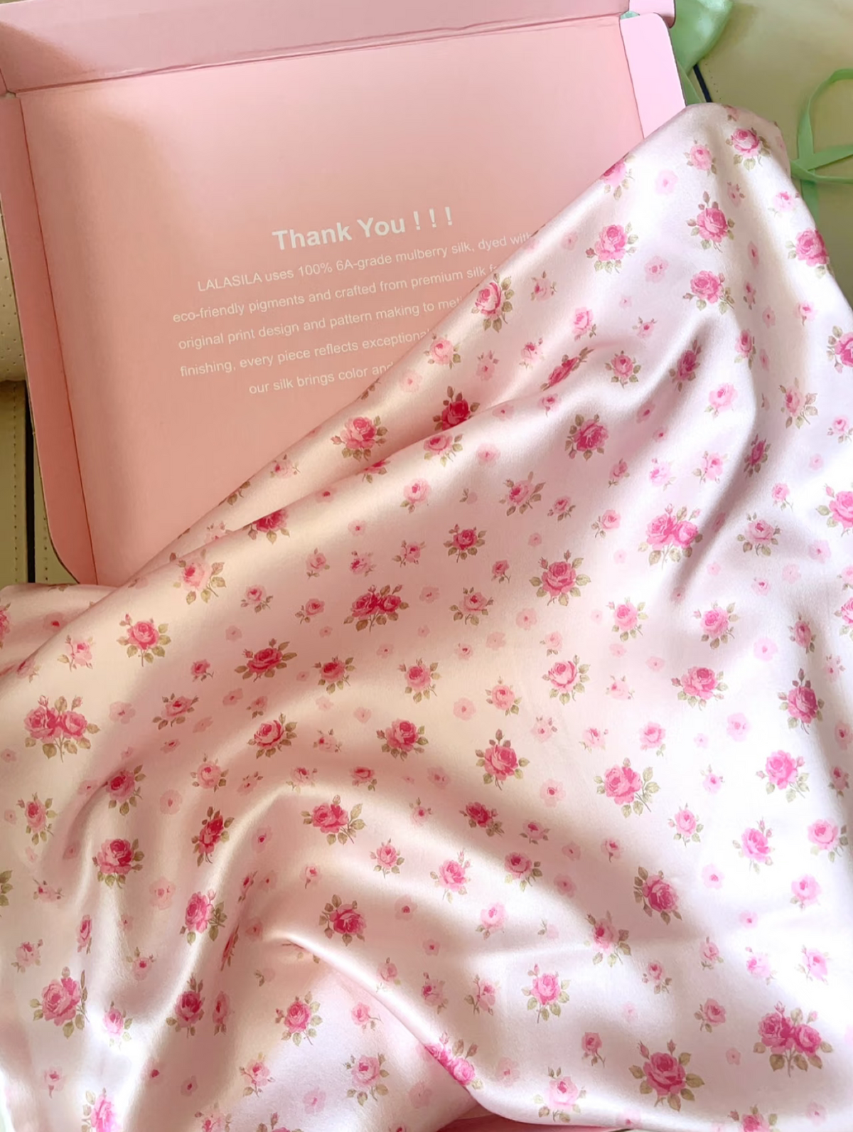 Rose story silk pillowcase with small pink roses beside a pink gift box