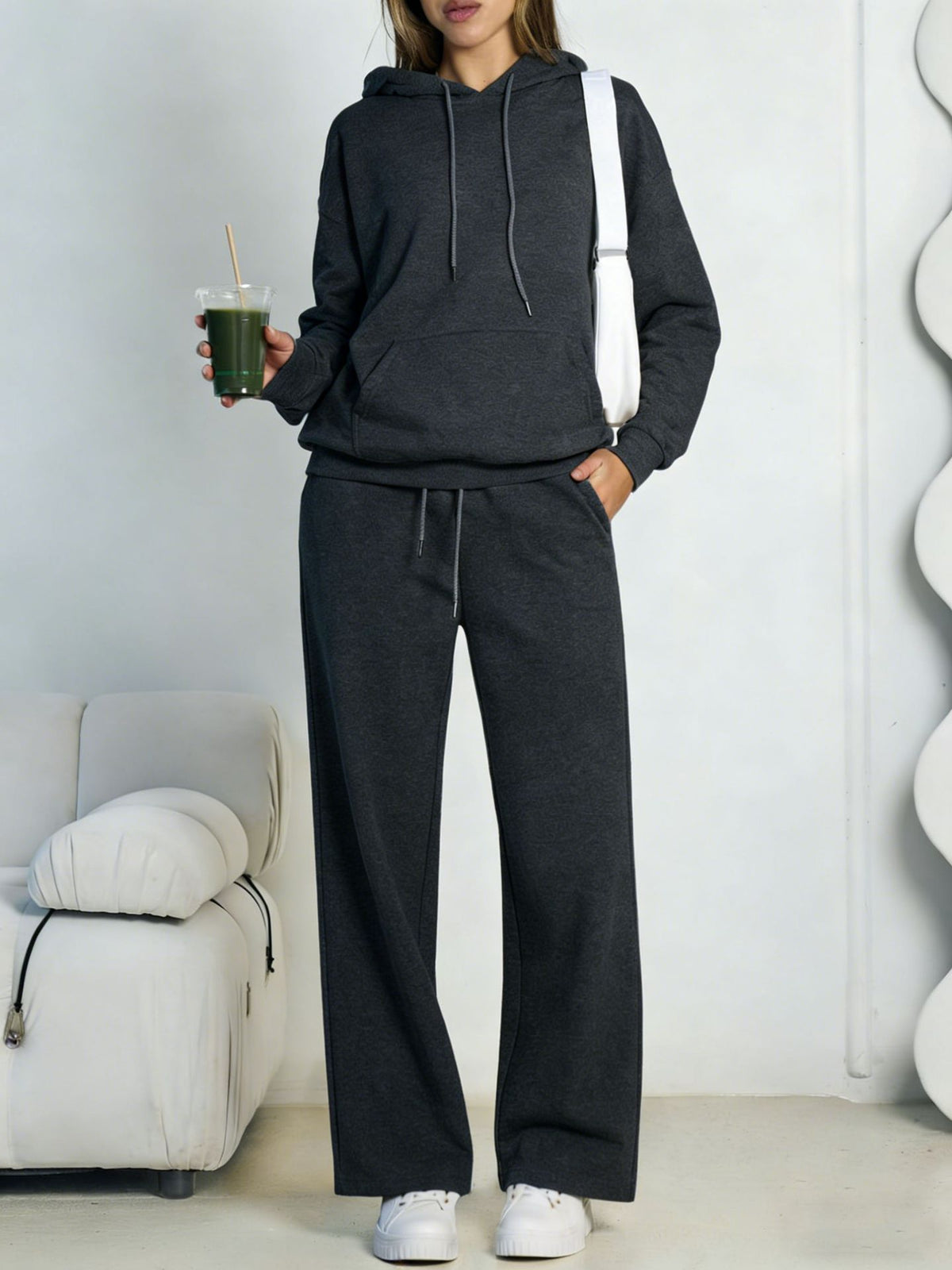 Dark gray fleece hooded sweatshirt and wide-leg sweatpants set worn by a model
