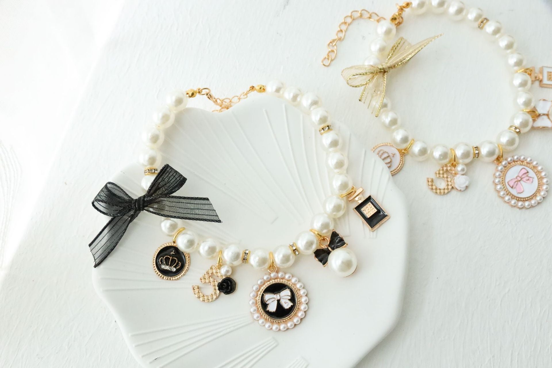 Ginger cat wearing a white faux pearl charm collar in a soft lifestyle photo