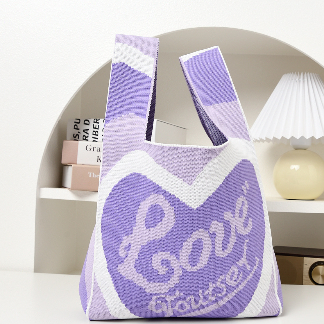 Knitted pattern wrist bag with a soft unstructured body and open top