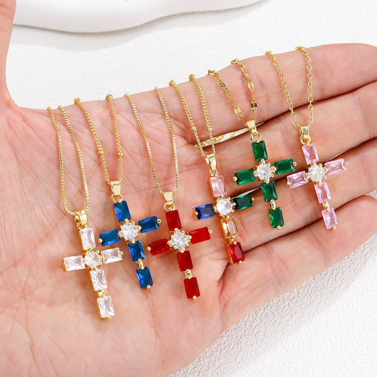 Gold tone cross pendant paved with clear cubic zirconia on a fine plated chain