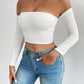 Close view of the straight bardot neckline of a white off shoulder long sleeve crop top