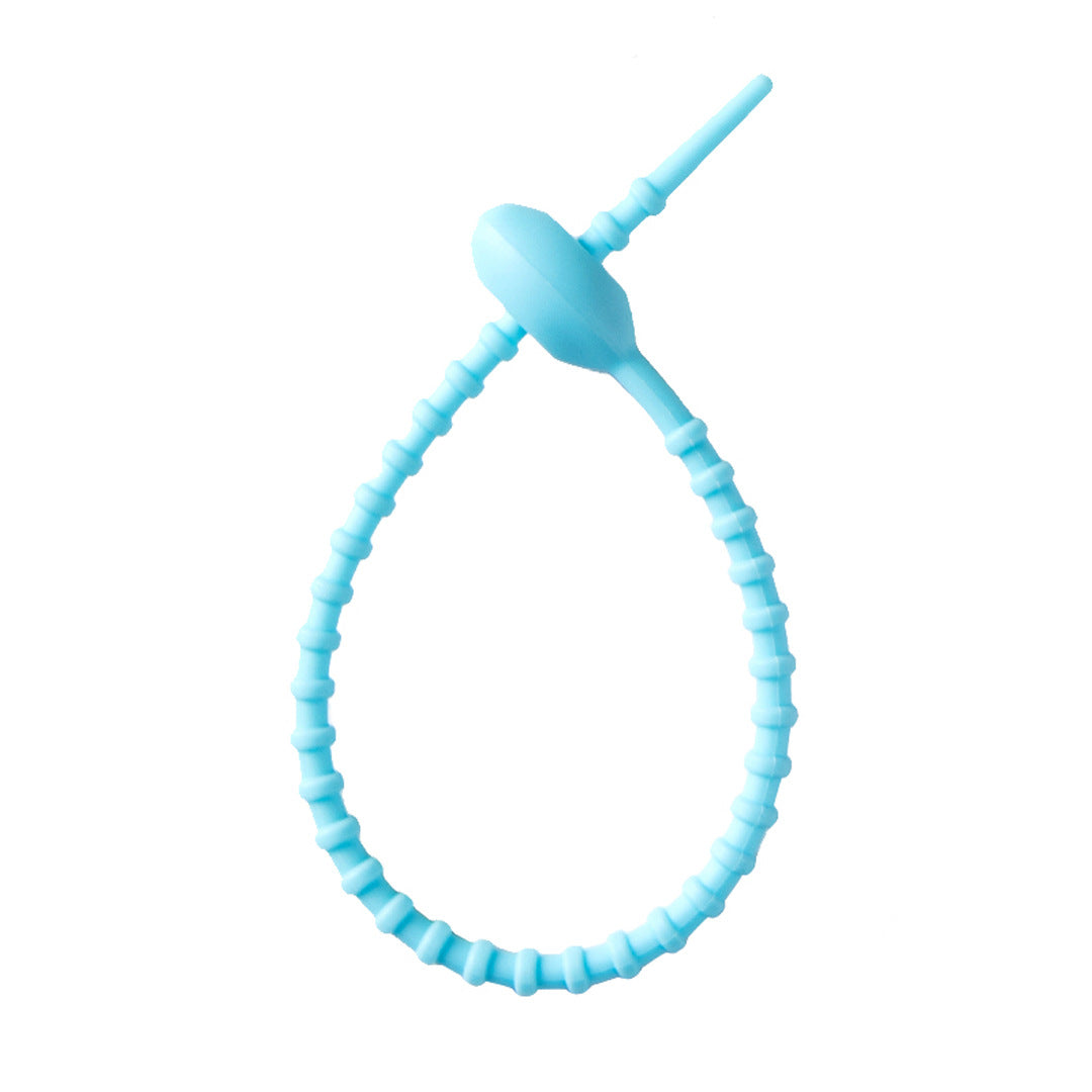 Tadpole silicone tie looped around a wrist to show how flexible the strap is