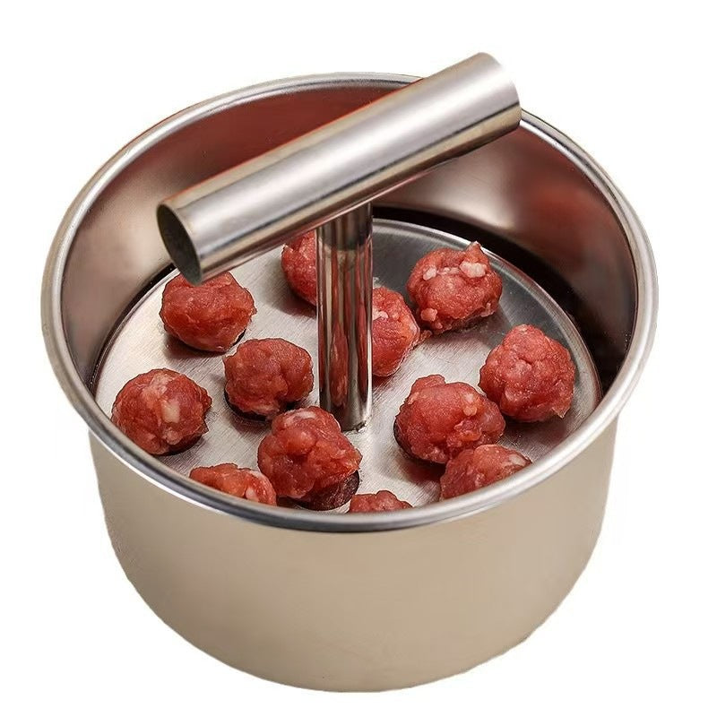 Small six hole stainless steel meatball press on a wooden board with fresh vegetables